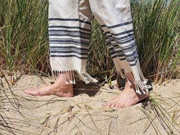 Les pieds d'un adulte dans le sable qui les massent et leur font du bien